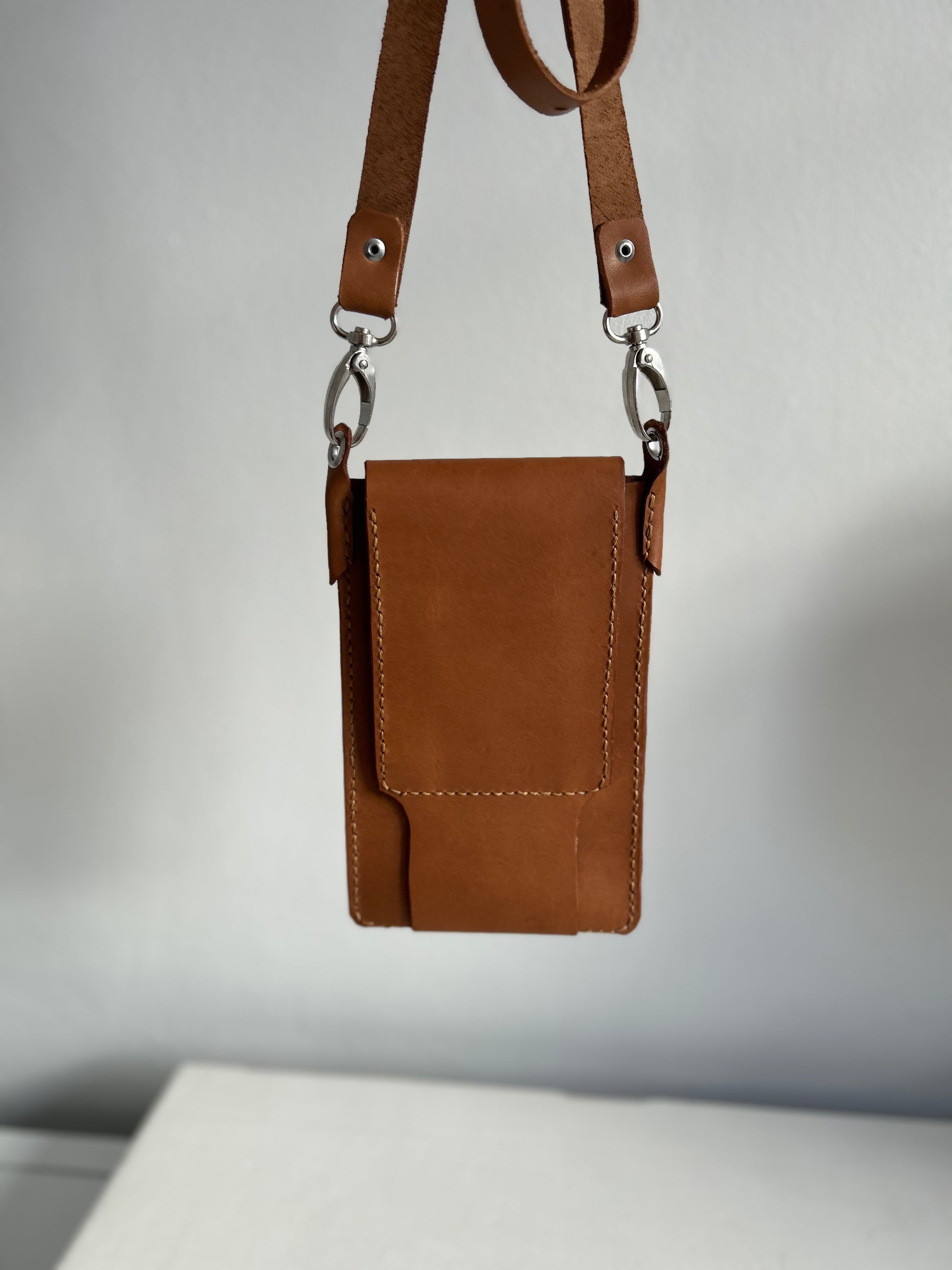 Light tan leather handbag suitable for holding a phone, one card and few smaller items. Back of bag shown