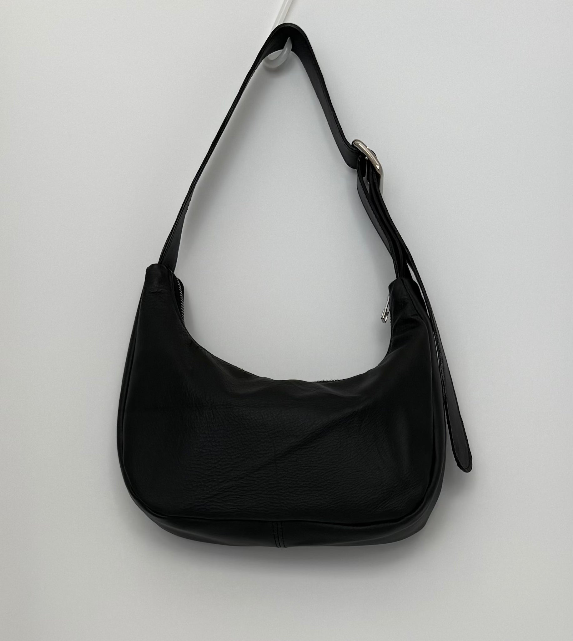 Black leather handbag with chrome zip and slider on a white background