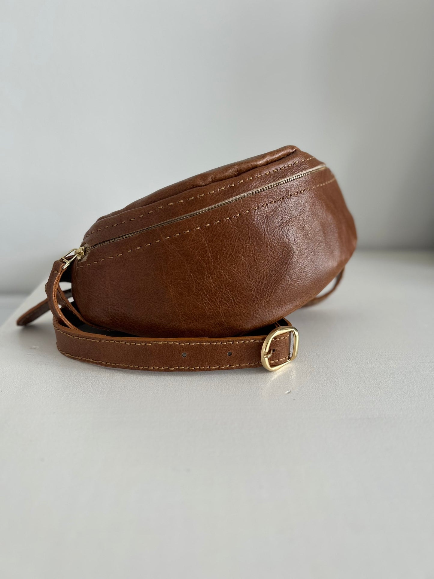 Dark tan leather moon bag with adjustable strap